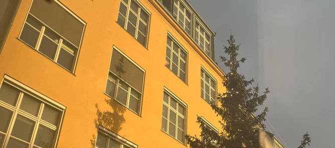 en høy bygning med et tre foran