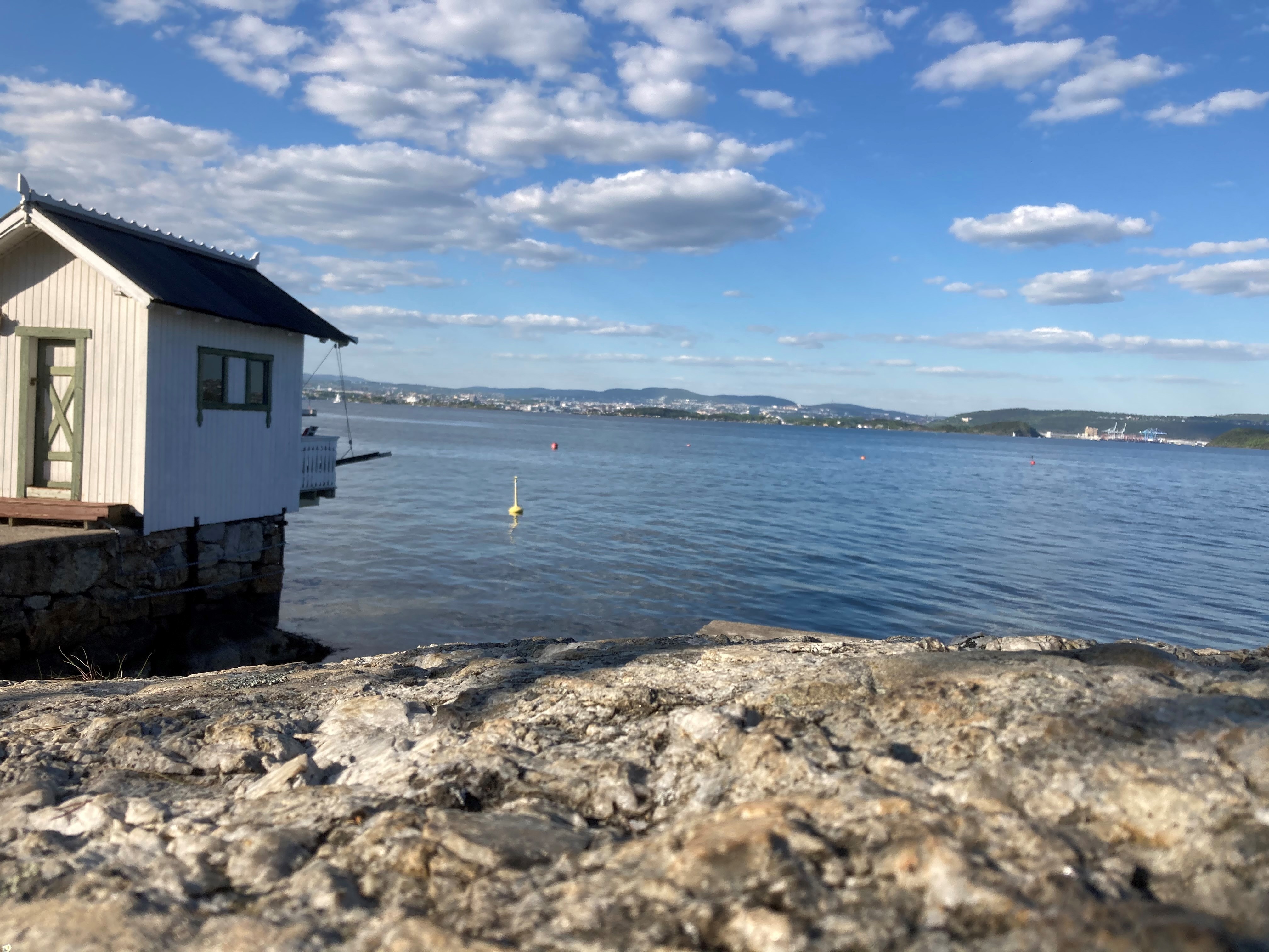Hvit badehus foran Oslofjorden i sommervær Hvit badehus foran Oslofjorden i sommervær